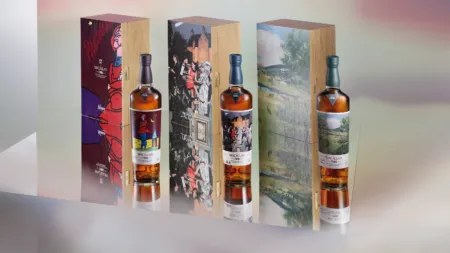 Row of three Macallan whisky bottles with decorative wooden boxes featuring artwork and labeled 1986.