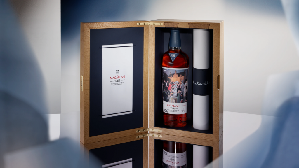 MAC-2026-RomanticaCollection-SupportingStatics-BMSPBBottleOpenBox16x9150dpiRGB-WEB - Petróleo y Energía Open wooden display case showing a Macallan 1986 whisky bottle against a dark blue interior with a certificate on the left panel.