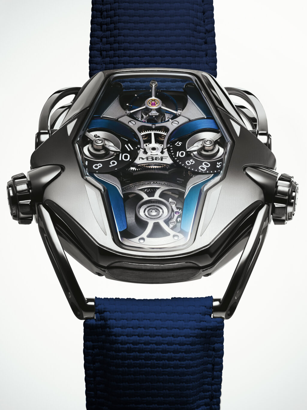 Stacked from 85 images Method=B R=4S=2 - Petróleo y Energía Close-up of a futuristic mechanical watch with exposed gears and a blue woven strap.