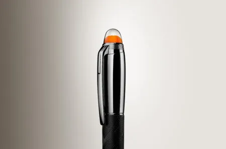 Close-up of a chrome lighter with an orange translucent cap and textured black grip, standing upright against a beige gradient.